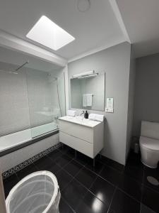 a bathroom with a sink and a toilet and a mirror at Oasis de César- Arquitectura Manriqueña in Costa Teguise +38 photos