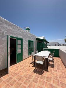 a patio with a table and chairs and a building at Oasis de César- Arquitectura Manriqueña in Costa Teguise
