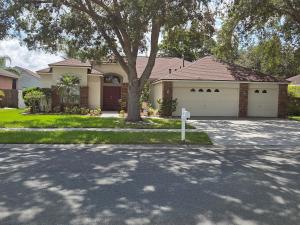 a house with a tree in front of a driveway at Accessible-Friendly Pool Retreat Extended Stay Welcome in Valrico