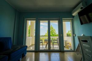 a living room with sliding glass doors and a patio at Neni apartament in Velipojë