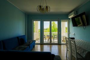 a living room with a couch and a sliding glass door at Neni apartament in Velipojë