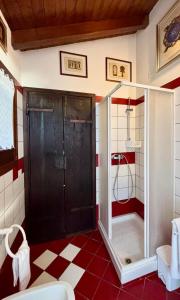 a shower in a bathroom with red and white tiles at Vista Lago B&B in Gavirate