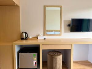 a room with a desk with a television and a mirror at Phi Phi Vista Nest Resort in Phi Phi Islands