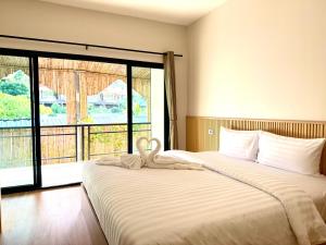a bedroom with two beds and a large window at Phi Phi Vista Nest Resort in Phi Phi Islands