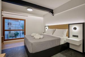 a bedroom with a large bed and a window at Agia Triada Suites in Heraklio