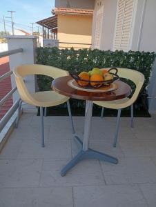 a bowl of fruit on a table with a chair at on the STRIP-Studio 1 in Kavos