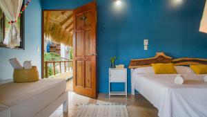 a bedroom with two beds and a blue wall at Punta Dreams in Brisas de Zicatela