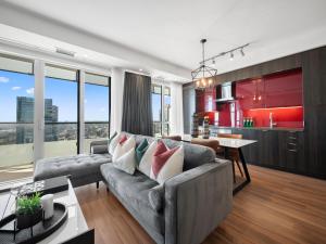 a living room with a gray couch and a kitchen at Avenue Suites - Toronto's Convention District in Toronto