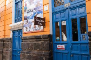 a blue door of a building with a sign on it at Hostal Café Tiana in Latacunga +31 photos