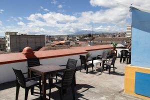 a patio with tables and chairs on a roof at Hostal Café Tiana in Latacunga