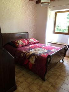a bedroom with a bed with a red comforter at Gîte Le Colombet in Audrix