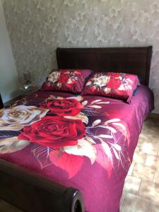 a bed with red roses on it in a bedroom at Gîte Le Colombet in Audrix