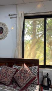 a bedroom with a window and a bed with pillows at The Nivasa Project in Agonda