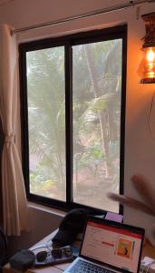 a laptop computer sitting on a desk in front of a window at The Nivasa Project in Agonda +3 photos