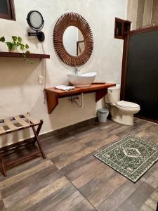 ein Badezimmer mit Waschbecken, Toilette und Spiegel in der Unterkunft El Roble Nature Hotel & Lagoon in Bacalar + 54 Fotos