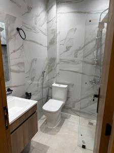 a bathroom with a toilet and a shower and a sink at اقامة هبة 1 in Yebha
