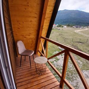 a porch with two chairs and a table and a field at Durmitor Holiday in Žabljak