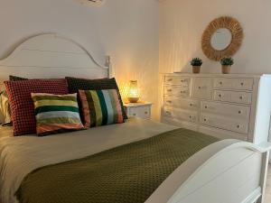 a bedroom with a bed with a dresser and a mirror at Appartement 2 - Est in Rimouski