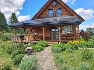 a log cabin with solar panels on its roof at Zakątek Lupkowski in Łupków
