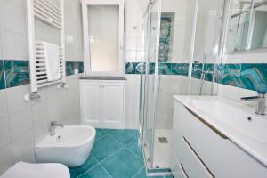 a white bathroom with a sink and a toilet at La Marilena Penthouse in Capri +21 photos