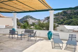 a patio with chairs and a table with a view at La Marilena Penthouse in Capri