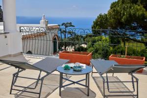 a patio with a table and chairs on a balcony at La Marilena Penthouse in Capri