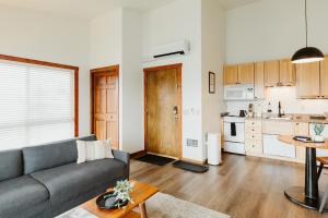 a living room with a couch and a kitchen at Mt Cleveland at Switchback Suites Boutique Hotel in Kalispell