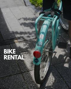 a blue bike parked on a sidewalk with the words bike rental at Casa Caravan - Plant Based Concept House in Buenos Aires