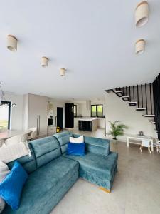 a living room with a blue couch and a kitchen at Pod Skrzydłami II in Liksajny
