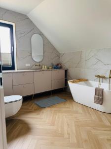 a bathroom with a white tub and a sink at Pod Skrzydłami II in Liksajny +33 photos
