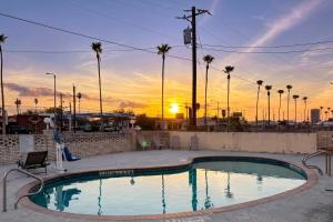 a swimming pool with a sunset in the background at Aloha Inn McAllen Airport near Medical center Tx in McAllen