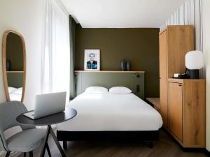 a bedroom with a bed and a laptop on a table at Mercure Grand Hôtel Metz Centre Cathédrale in Metz +56 photos