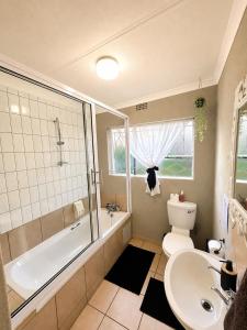 a bathroom with a tub and a toilet and a sink at Zhantique Guest House 2- Unit 3 in Boksburg