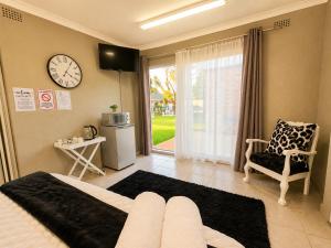 a bedroom with a bed and a clock on the wall at Zhantique Guest House 2- Unit 3 in Boksburg
