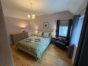 a bedroom with a bed and a chair at Snowdrop Cottage in Orkney