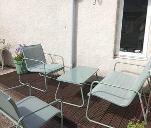 a group of chairs and a table on a patio at Snowdrop Cottage in Orkney