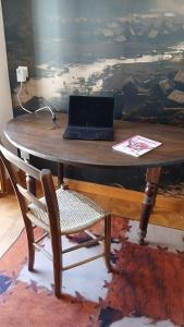 a wooden table with a laptop sitting on top of it at La Couleur des Temps in Couiza
