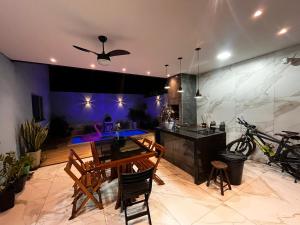 a kitchen with a table and chairs in a room at Casa Temporada Aconchego e tranquilidade 3 in Bonito
