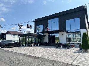 a black building with a car parked in front of it at Hotel Taurus in Solotvyno