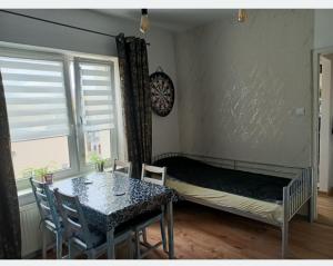 a bedroom with a bed and a table and chairs at Centrum 3 łóżka Roosevelta 47 in Piła