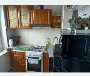 a kitchen with a stove and a microwave at Centrum 3 łóżka Roosevelta 47 in Piła