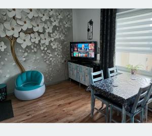 a living room with a table and a chair and a television at Centrum 3 łóżka Roosevelta 47 in Piła