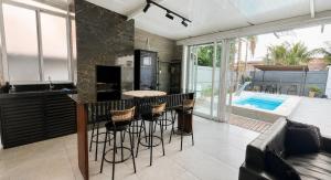 a kitchen with a bar and a swimming pool at Casa no Litoral , com Piscina Privativa em Ubatuba in Ubatuba