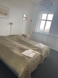 a bedroom with a bed with two towels on it at carlsens hotel in Vesterø Havn