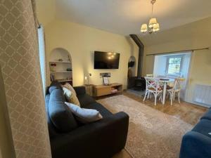 a living room with a couch and a dining room at Snowdrop Cottage in Orkney