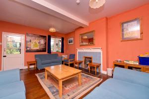 a living room with orange walls and a fireplace at YHA Eskdale in Eskdale