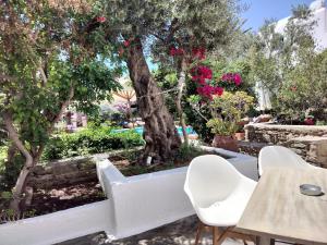 a table and chairs and a tree with pink flowers at Andromeda Residence in Mikonos