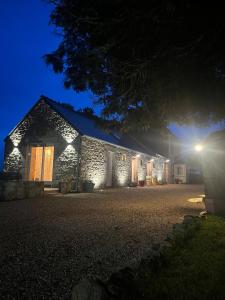 a stone house at night with lights on at Ty glaz in Plouguerneau