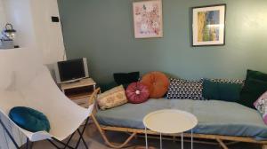 a living room with a couch and a table at Maisonnette de vignes avec vue imprenable in Marvejols