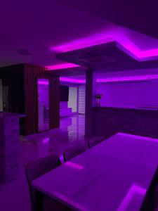 a room with purple lights and tables and chairs at Villa Imperium Indoor & Outdoor Pool Riverfront Bjelašnica View in SJJ +52 photos
